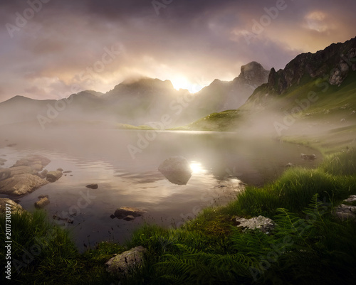 Schilderij op canvas Mountain lake reflecting sun through morning fog