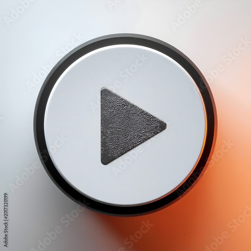 A top down view of a round white button with a dark play symbol.