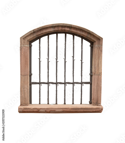 Ancient arched window frame made of red sandstone with a decorative wrought iron security grill isolated on white