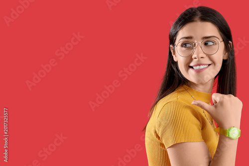 Bild auf Leinwand Young gossip woman pointing at something on red background