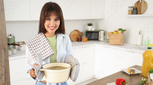 Young woman with tasty soup...