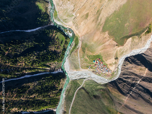 Obraz na płótnie High altitude remote settlement in a rugged valley where teal glacial waters mee