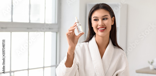 Young woman holding serum w...