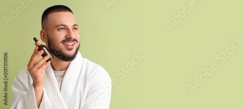 Young man holding bottle of...
