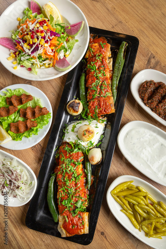 Fotografi Turkish kebab, beyti sarma, and side dishes.