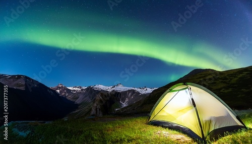 tourist tent at night with beautiful aurora borealis and mountains in the background concept of adventure travel mountain climbing nature tourism concept with tent