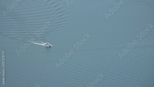 Aerial view of a solitary motorboat cruising on the calm blue water of Lake Geneva, Switzerland