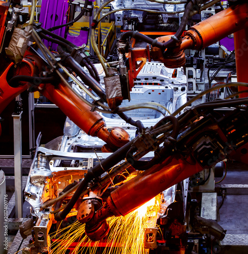 Quadro em tela Automated robotic arms are welding on the car body production line