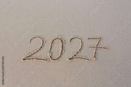 2027 hand written in sand on a beautiful beach