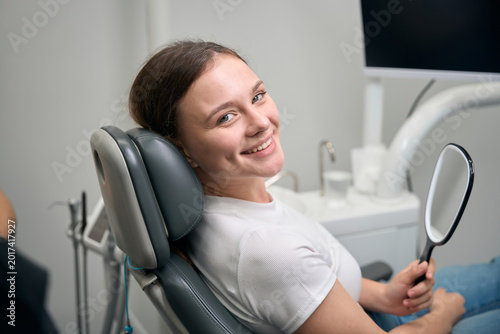 Young Caucasian woman smiling in dental office during examination