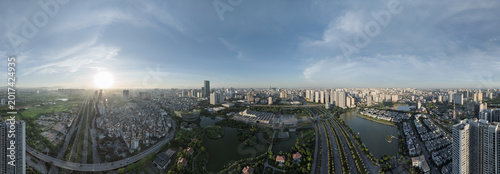Quadro su tela Wide daytime aerial panorama of western Hanoi with lakes, boulevards, dense urban districts, and dramatic cloudy sky
