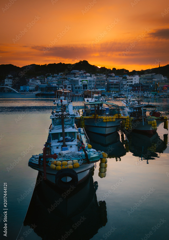 Fototapeta premium Sunset seascape with moored fishing boats at the Gangguan Port in Tongyeong‑si, Gyeongsangnam‑do, South Korea