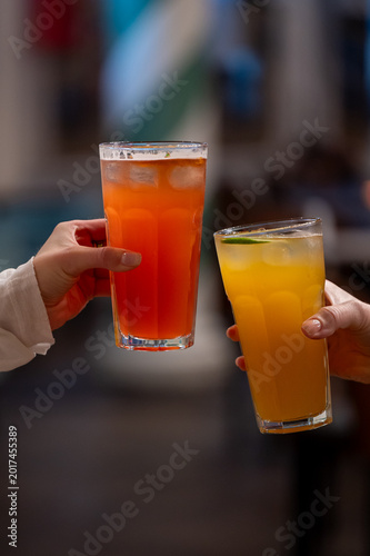 Fotografía Two hands toast with glasses of iced fruit cocktails