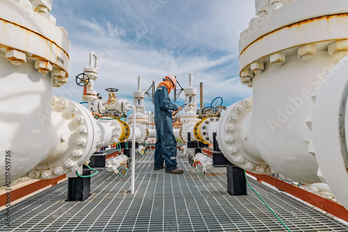 Male worker inspection at steel long pipes and pipe elbow in station oil factory during refinery valve of visual check record pipeline tank oil