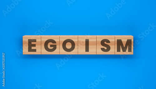 Photos Egoism on Blocks: The word Egoism spelled out with wooden blocks, a stark symbol of self-centeredness laid against a solid, stark blue backdrop