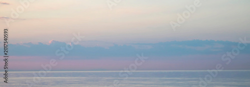 Canvas-taulu Calm pastel seascape at sunrise with soft clouds and a tranquil horizon over wat
