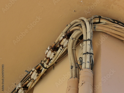 Εκτύπωση καμβά Bundled cable installation with traces of rust on a house wall in typical improvised electrical installation in Mediterranean architecture
