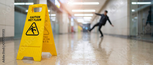 A cautionary image that captures the moment of a slip and fall incident, emphasizing the significance of safety precautions, focusing on the warning sign and the immediate hazard.