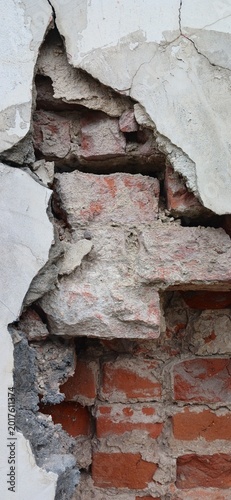 Close-up of an old brick wall with chipped and cracked plaster