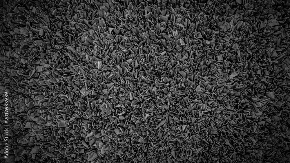 Fototapeta premium Close view of a textured surface made of fabric in a dark color showing folds and wrinkles in an abstract design