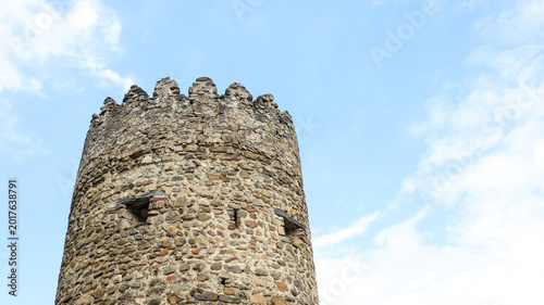 Foto Weathered stone tower with battlements topping an old fortress wall, showcasing