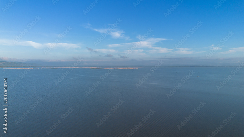 Obraz premium Aerial View of Calm Blue Lake Under a Cloudy Sky
