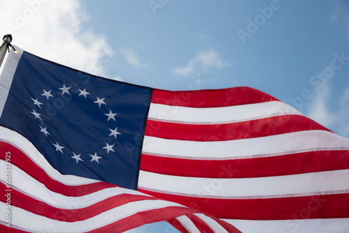 Canvastavla Besty Ross American Flag blowing in strong breeze against cloudy blue sky