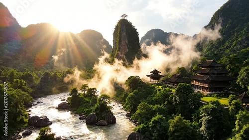 Misty sunrise over ancient temple, river, and lush green mountains