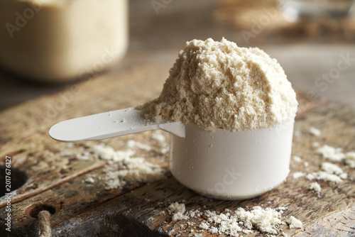 Whey protein powder in a measuring spoon