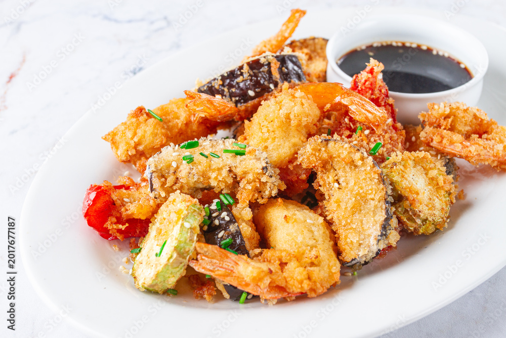 Fototapeta premium Shrimp and vegetable tempura, served with dipping sauce, on a white plate