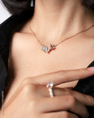 Luxury beauty portrait featuring elegant butterfly pendant necklace combined with sparkling diamond ring on stylish female model. Premium jewelry concept suitable for fashion branding