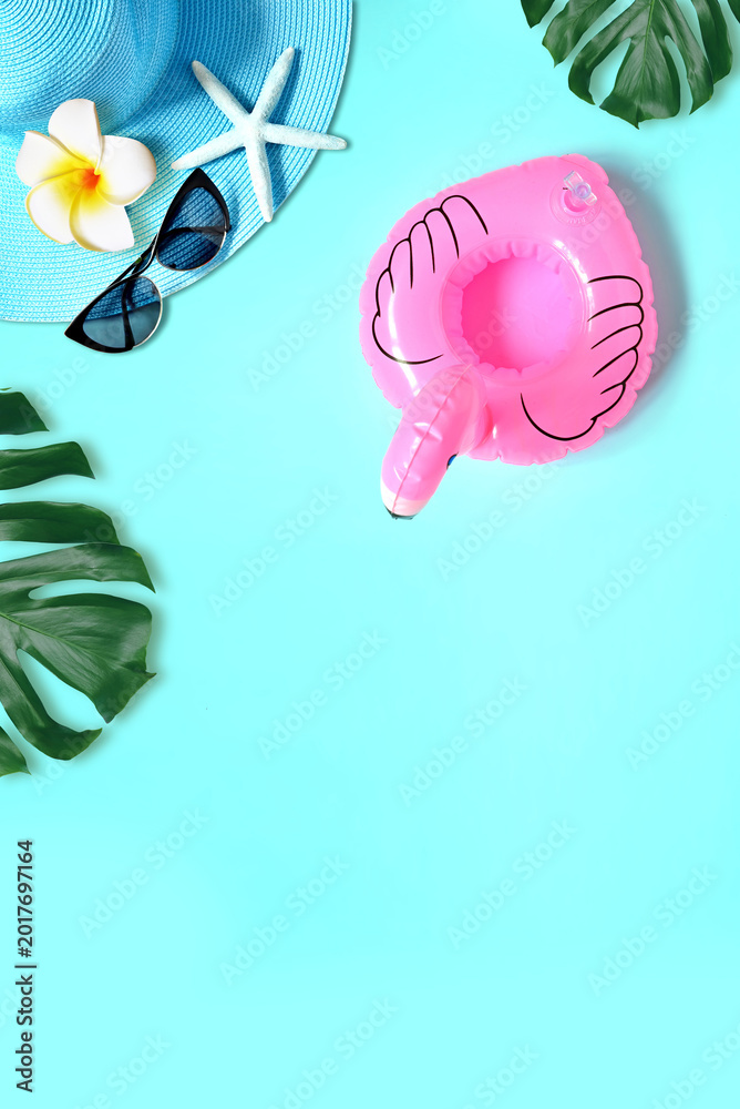 Fototapeta premium Tropical summer beach background. Palm trees branches, hat with starfish and flamingo on blue summer background. Summer concept.