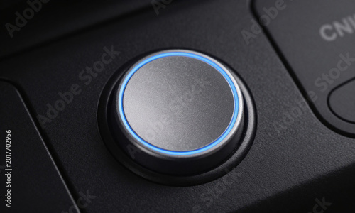 metallic grey circular start button centered sleek black control panel illuminated soft blue led glow direct overhead studio