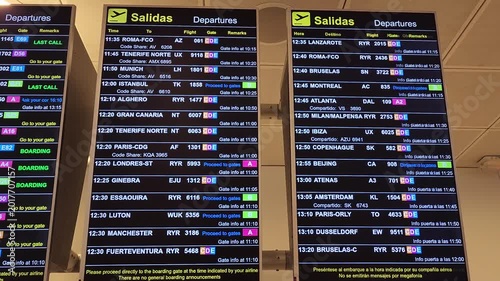Electronic screen board with flight departures information in a Spanish airport terminal.