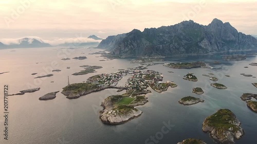 Drone orbit flight over water around Henningsvær island village center, Lofoten Islands Norway aerial cinematic