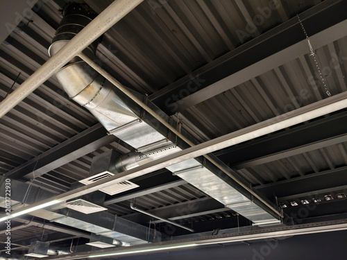 Factory ceiling equipped with extensive ventilation and piping system designed to support industrial operations and maintain air quality