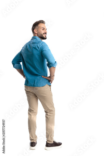 Back view of confident casual man standing looking away