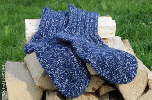 Woolen socks on a stack of firewood in the garden.
