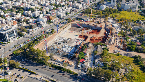 Tableau sur toile Construction site with multiple cranes and ongoing foundation work showing urban