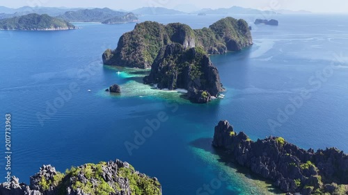 Dramatic limestone islands rise in Bacuit Bay, El Nido. This scenic area in the Philippines is a popular vacation destination due to its beautiful coral reefs, beaches, and hidden lagoons.
