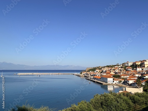 Koroni Greece, Mediterranean coastal town with red roof houses and calm blue sea under clear sky
