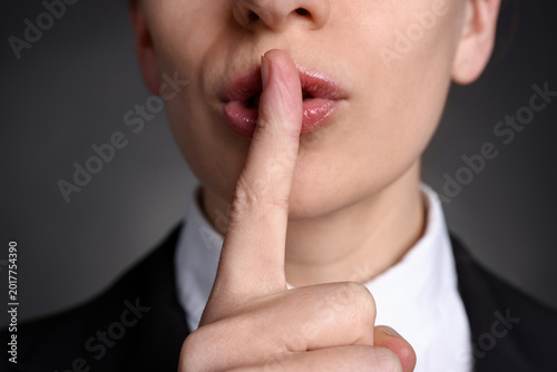 Photos Woman showing hush gesture on grey background, closeup