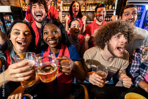Group of friends cheering during live sports match in pub