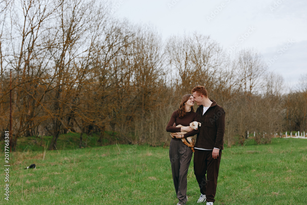 Obraz premium Couple, outdoor, lifestyle, dog, joy, nature, field, grass, smiling, autumn, trees, countryside, pet, affection, together, fashion, casual, atmosphere, serene, breeze, carefree, moment, family,