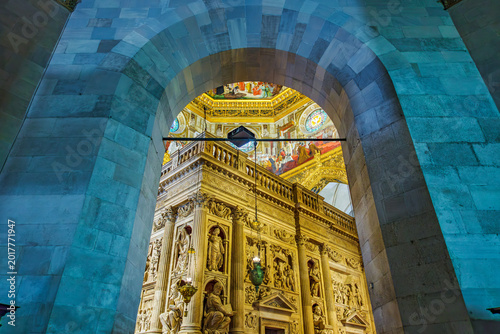 Basilica della Santa Casa interior seen through a Roman arch, revealing ornate marble enclosure, sculpted details and colorful dome frescoes in Loreto, Italy pilgrimage site