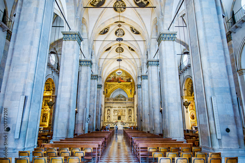 Loreto basilica interior with towering columns, vaulted ceilings and rows of pews leading to an ornate altar, evoking solemn spirituality and historical grandeur in Italy