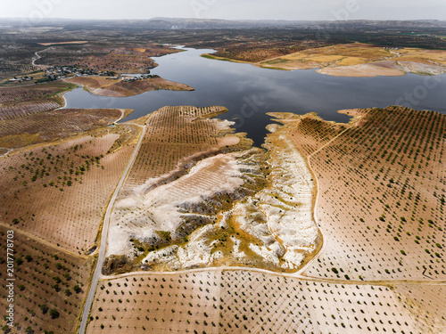 Fotografia Pistachio orchards on heavily eroded semi-arid terrain with calcareous badlands formations