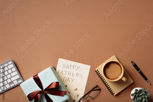Father's Day gift and office accessories on brown background. Top view flat lay