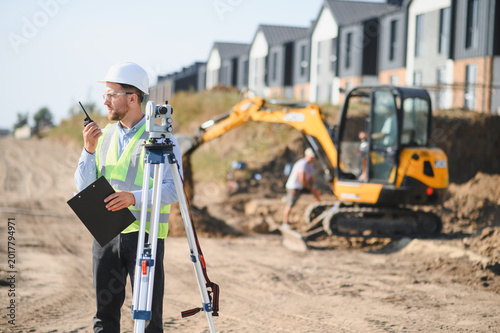 Fotografie Surveyor using total station and radio at construction site
