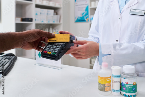 Quadro su tela Close up of customer paying by credit card at pharmacy counter, pharmacist processing contactless transaction for prescription purchase